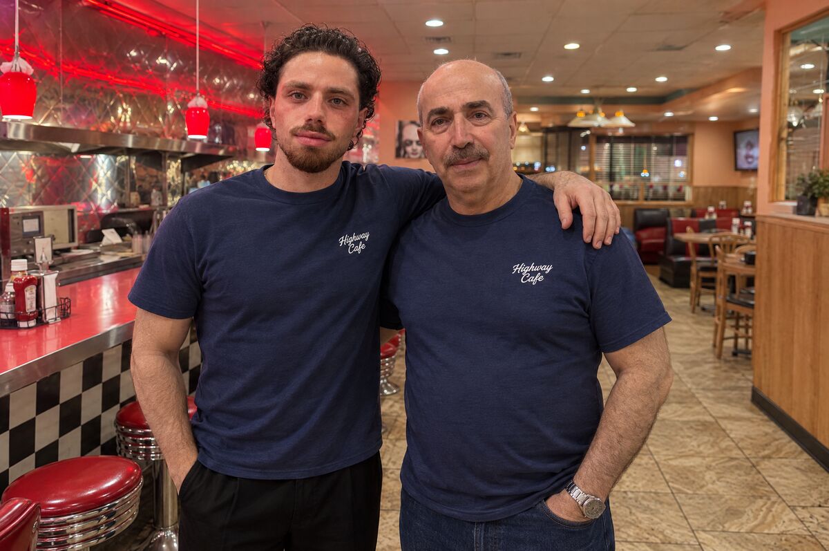 Ali and his son Hesam in navy Highway Cafe shirts at the checkerboard counter